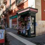 ...imbocchiamo via Sparano. Qui, ad angolo con via Piccinni, si trova il chiosco centenario gestito dalla 55enne Maria Genchi, pi� stretto e piccolo rispetto a quelli incontrati sinora